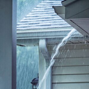 water pouring out of roof gutter during storm