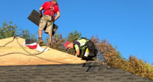 roofers installing asphalt shingles
