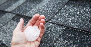 someone holding a piece of hail on a roof